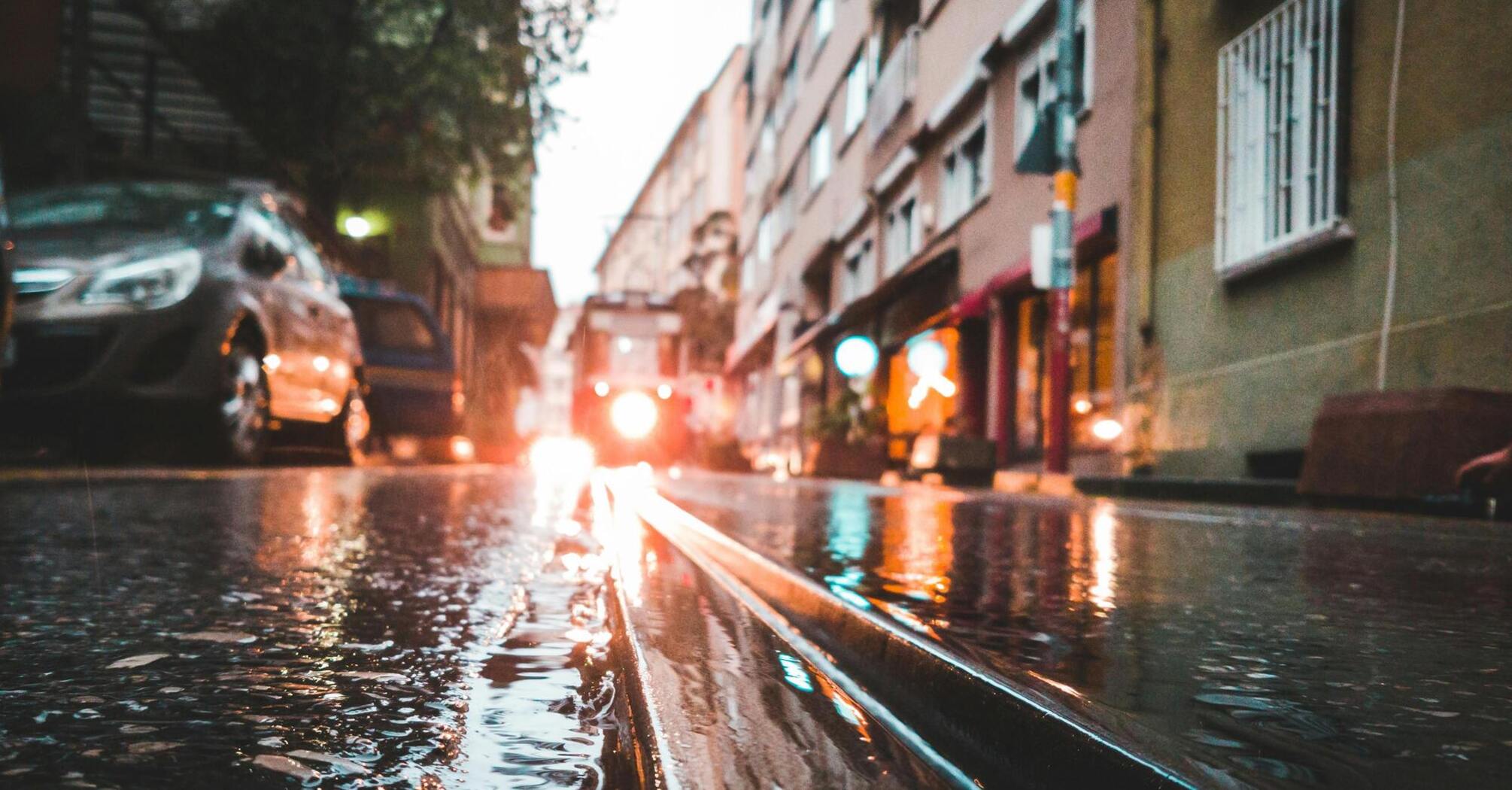 Rain-soaked street with reflections of city lights