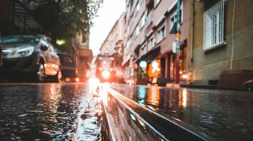 Rain-soaked street with reflections of city lights