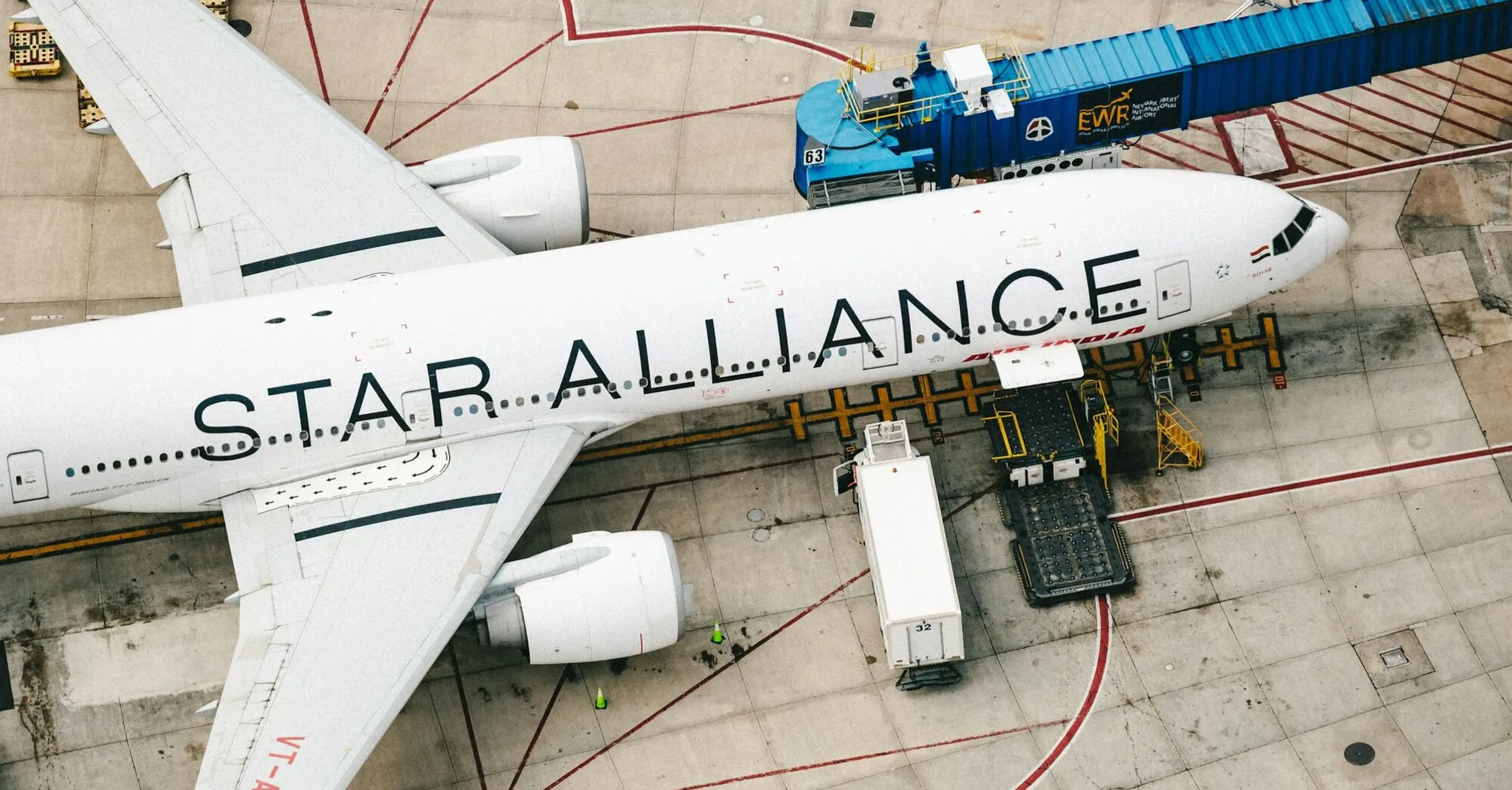 A Star Alliance plane parked at an airport gate, seen from above