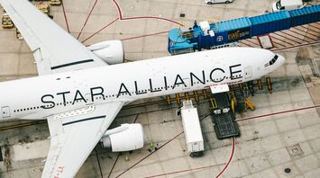 A Star Alliance plane parked at an airport gate, seen from above