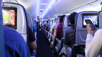 Passengers seated inside an airplane cabin during flight
