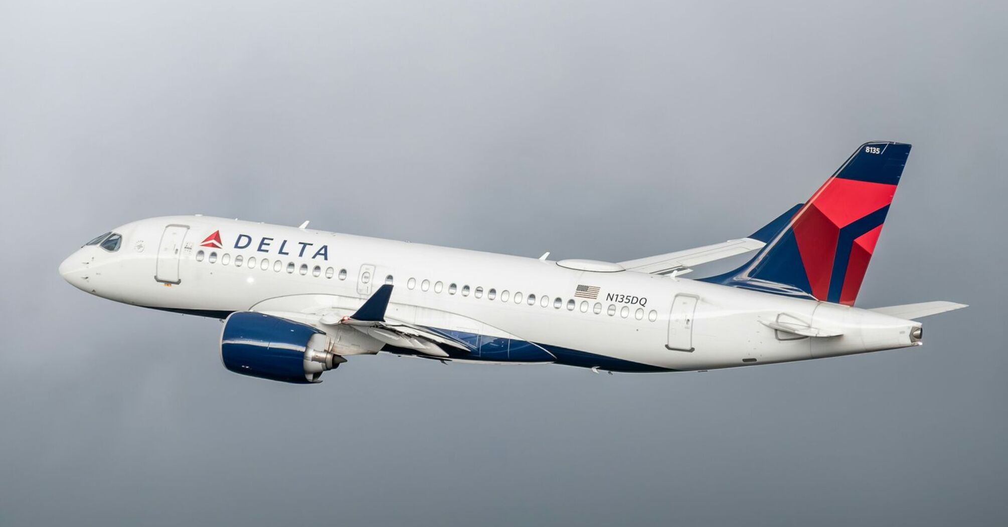 Delta Air Lines aircraft in mid-flight against a cloudy sky