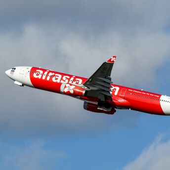 AirAsia plane taking off against a cloudy sky
