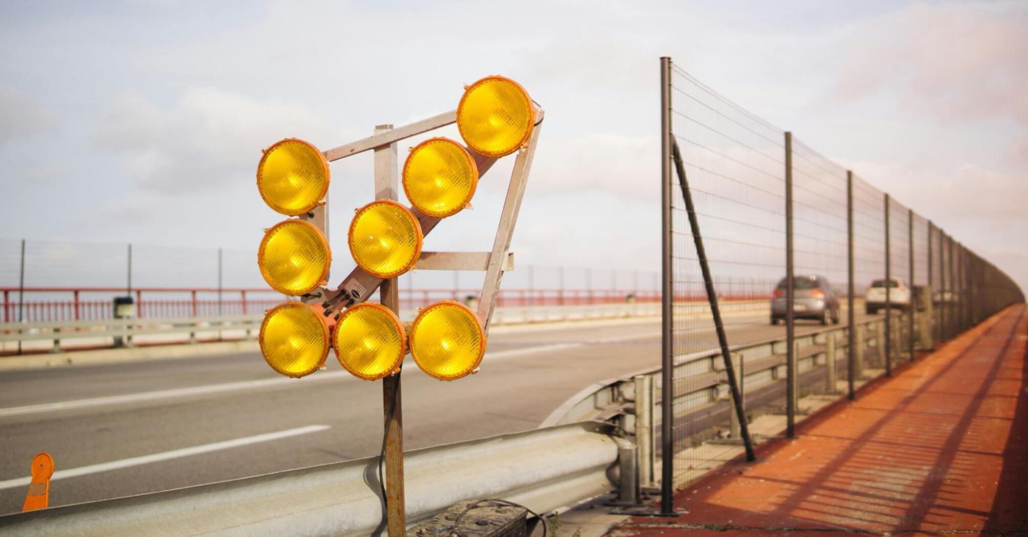 Construction warning lights on a highway, indicating roadwork and potential traffic delays