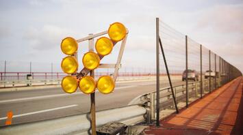 Construction warning lights on a highway, indicating roadwork and potential traffic delays