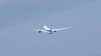 a large passenger jet flying through a blue sky