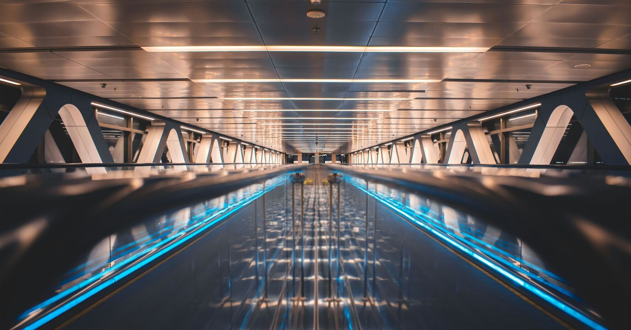 a very long and empty walkway with blue lights