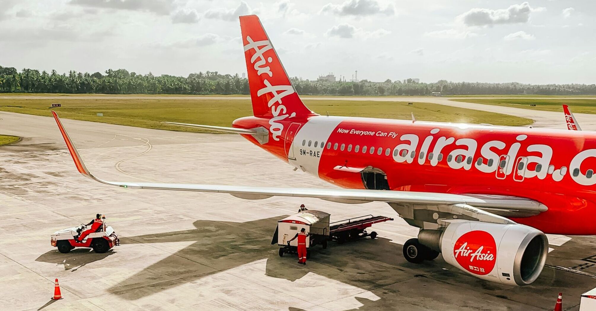 AirAsia aircraft being prepared for departure on the runway with ground crew