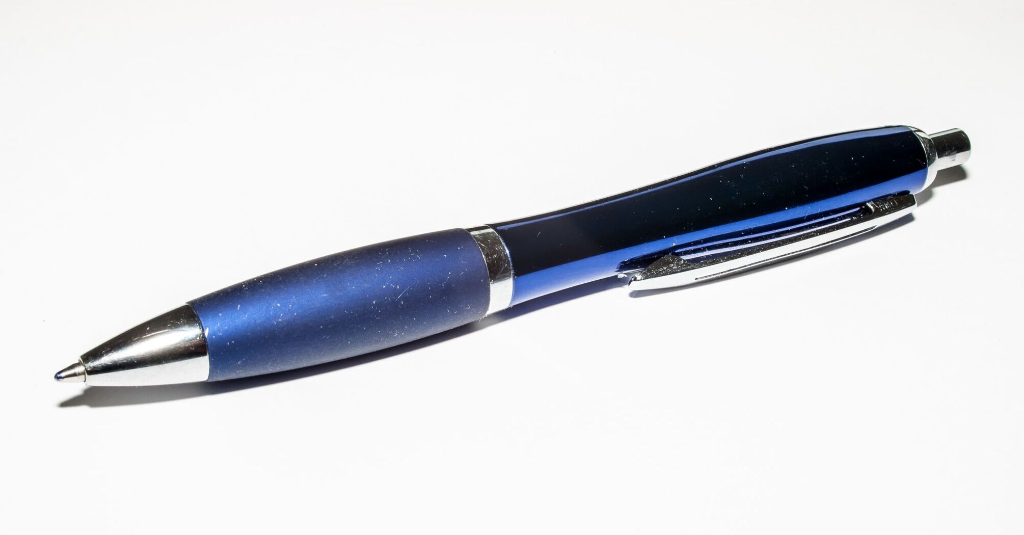 A blue ballpoint pen on a white surface