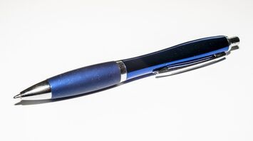A blue ballpoint pen on a white surface