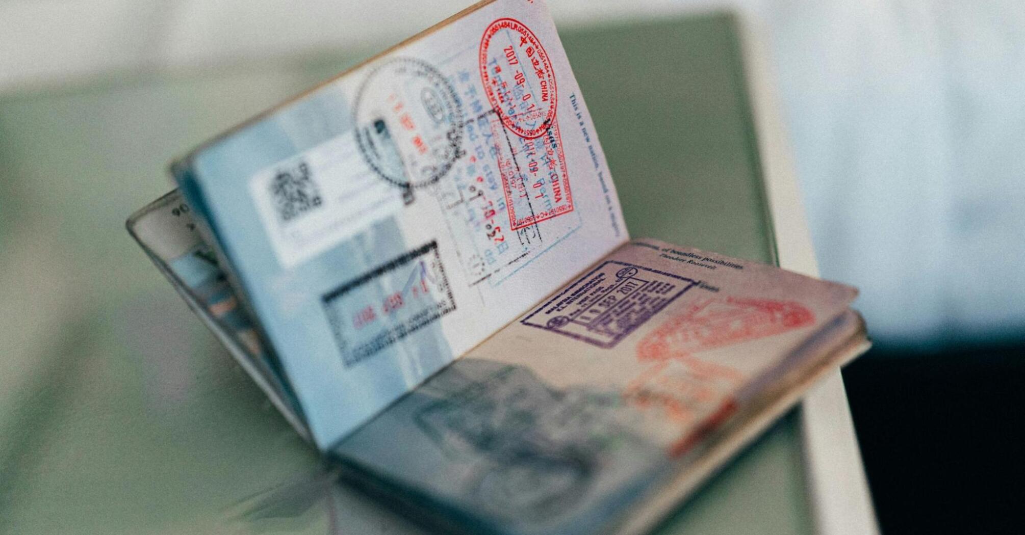 Open passport with multiple stamps from various countries, resting on a flat surface