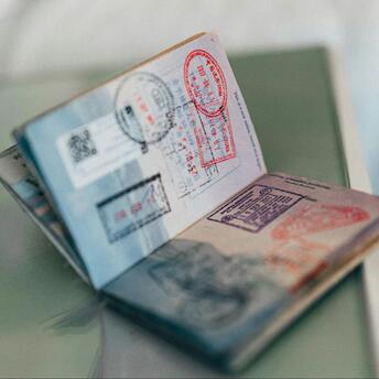 Open passport with multiple stamps from various countries, resting on a flat surface