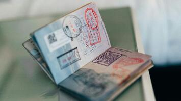 Open passport with multiple stamps from various countries, resting on a flat surface
