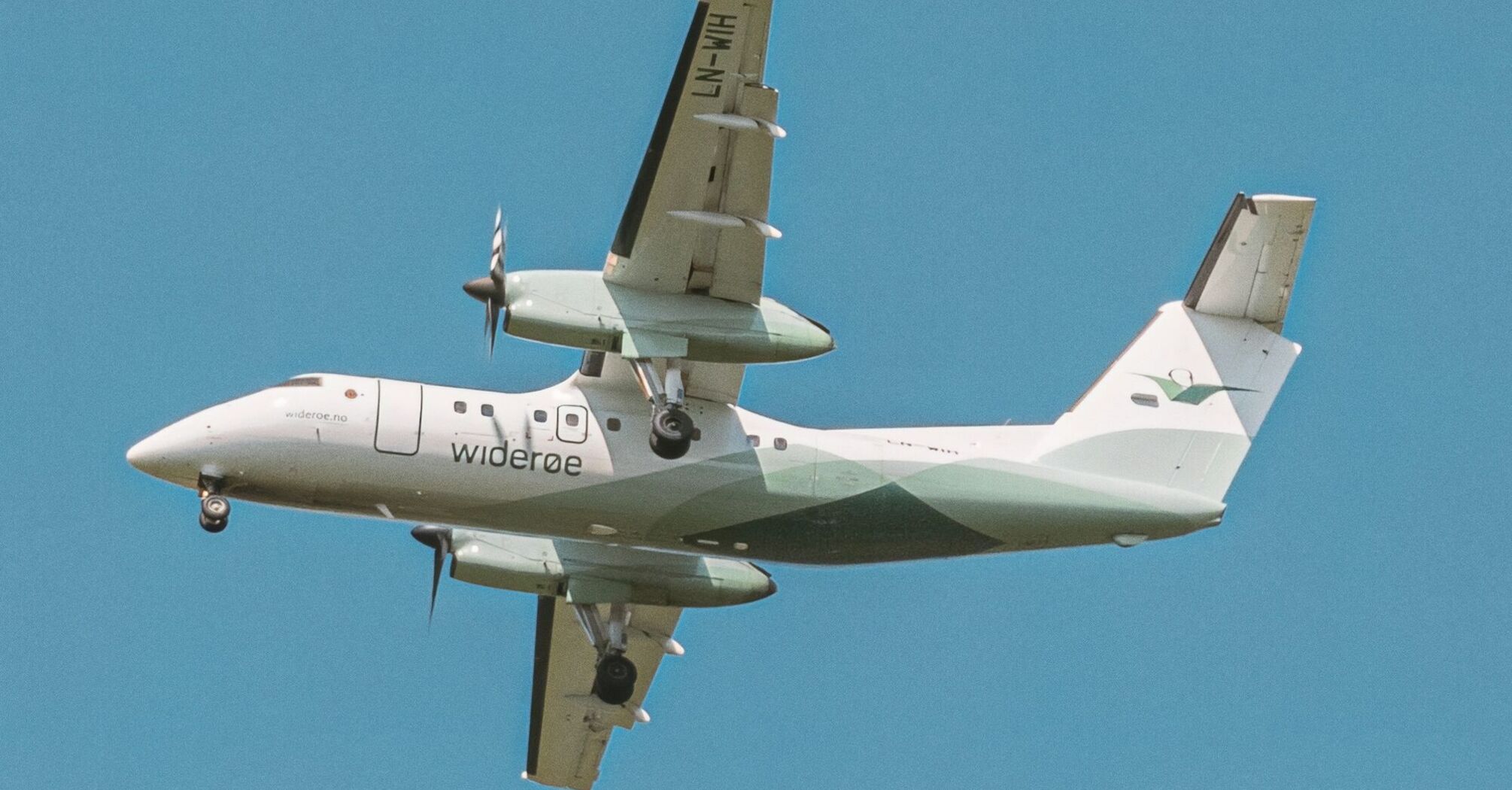 Widerøe regional aircraft flying in clear blue sky