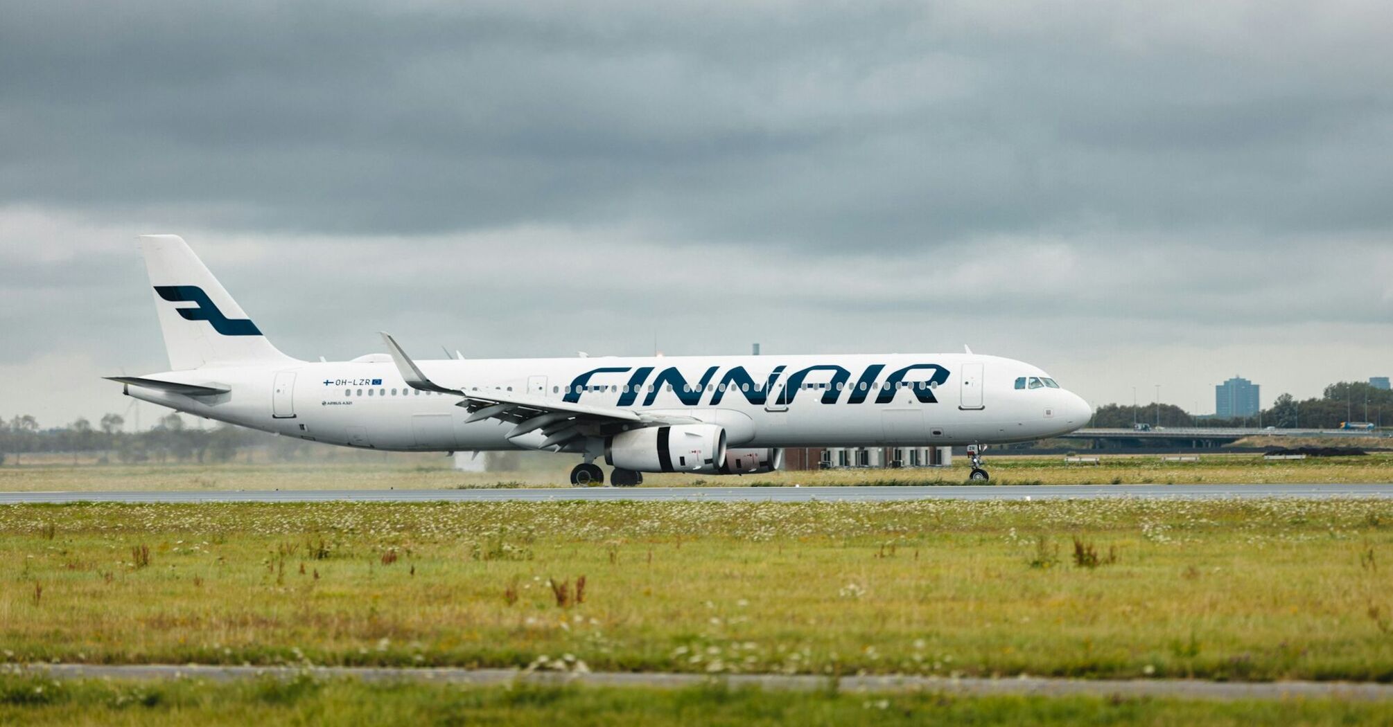 A Finnair aircraft on the runway under cloudy skies, ready for departure