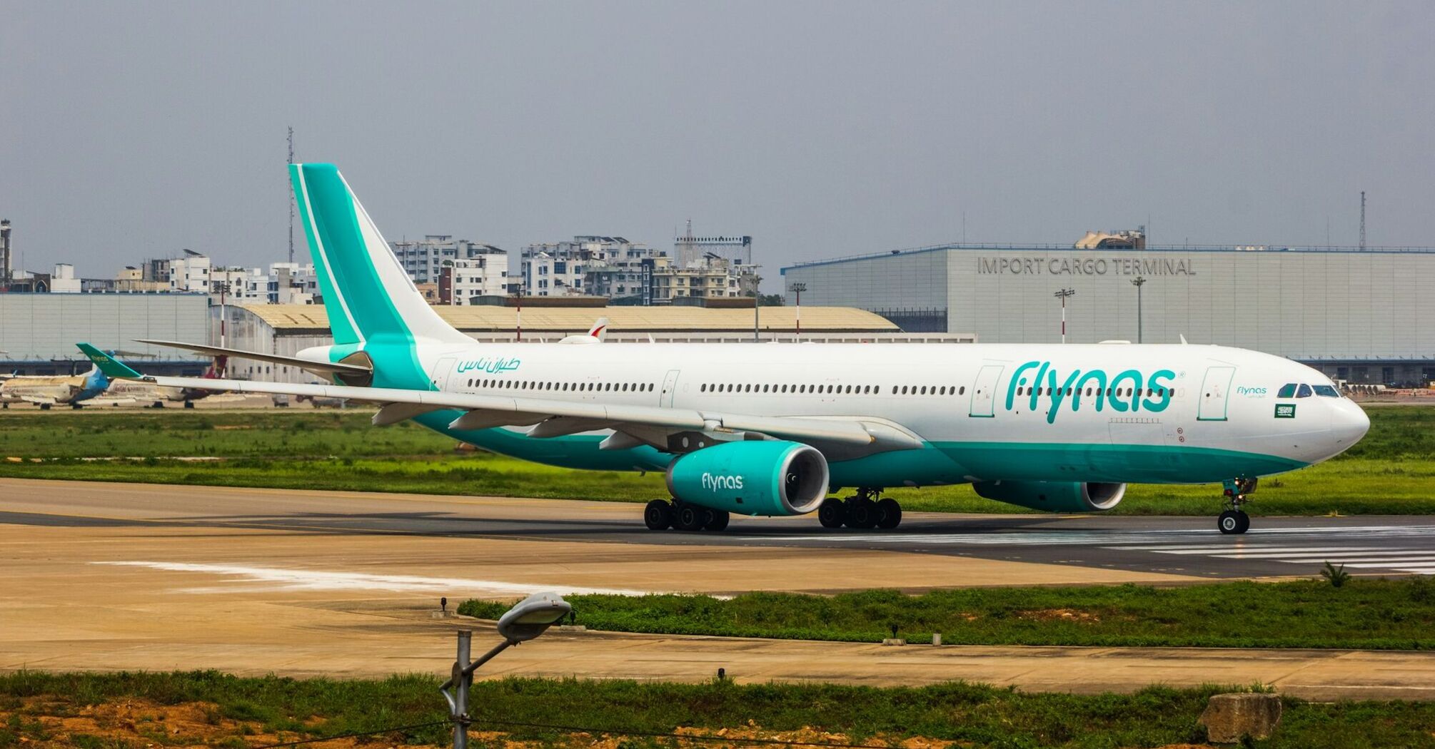 A flynas aircraft taxiing on a runway at an airport