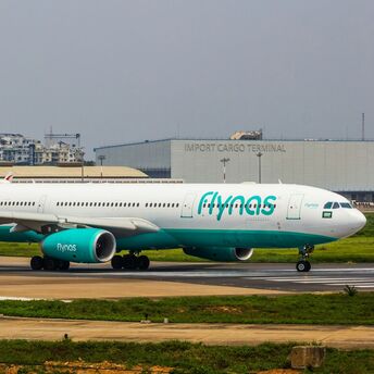 A flynas aircraft taxiing on a runway at an airport