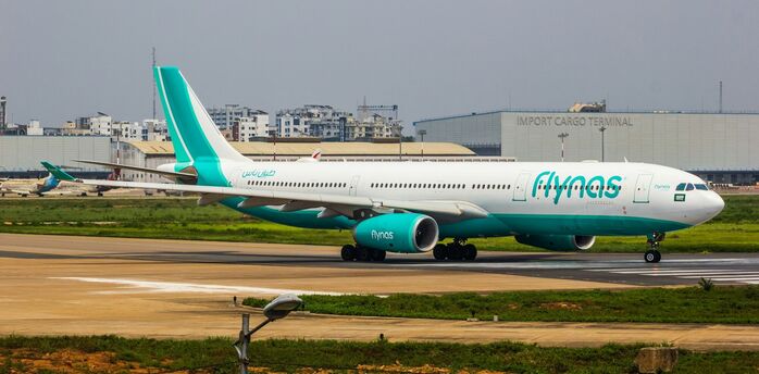 A flynas aircraft taxiing on a runway at an airport