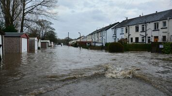 Flooded residential street in northern England with houses and garages submerged in water