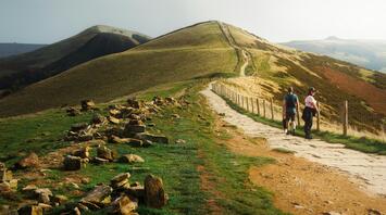 Hikers on a scenic English trail through rolling hills