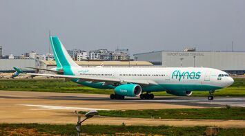 A flynas airplane on the runway at an international airport, highlighting the airline's operations
