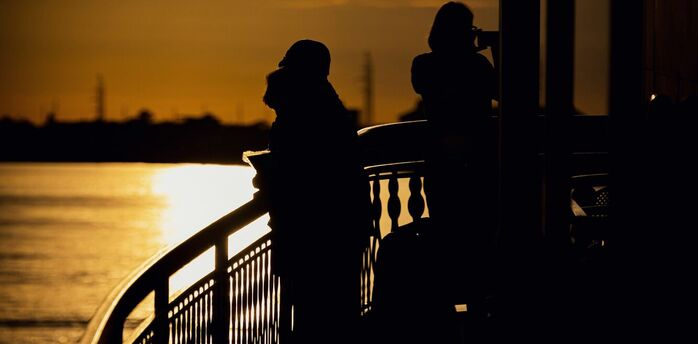 Silhouetted travelers enjoying a river cruise during a golden sunset
