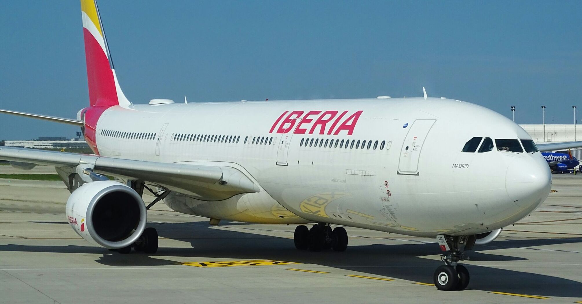 An Iberia airplane on the runway at an airport