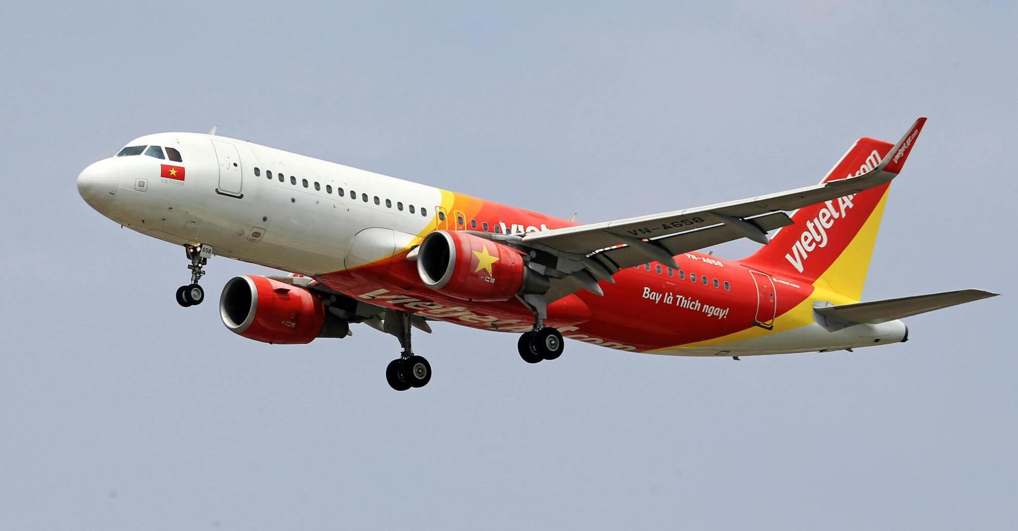 A Vietjet airplane preparing to land, showcasing its distinctive red and yellow livery