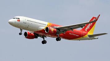 A Vietjet airplane preparing to land, showcasing its distinctive red and yellow livery