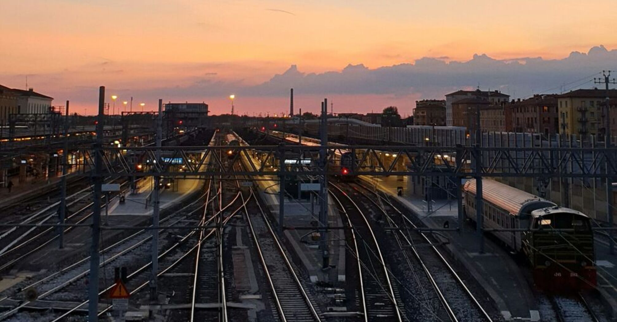 Sunset view over railway tracks at a train station in Italy