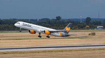 A Condor Airlines plane taking off from a runway on a clear day