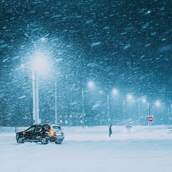 Snowstorm at night with a car