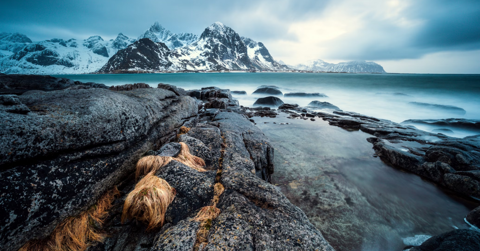 Rugged Arctic shoreline with snow-capped mountains in Lofoten, Norway