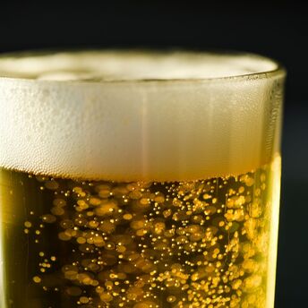 A glass of golden beer with foam on top