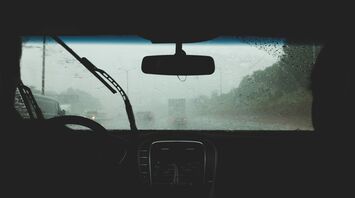 View from inside a car during heavy rain, with blurred visibility through the windshield