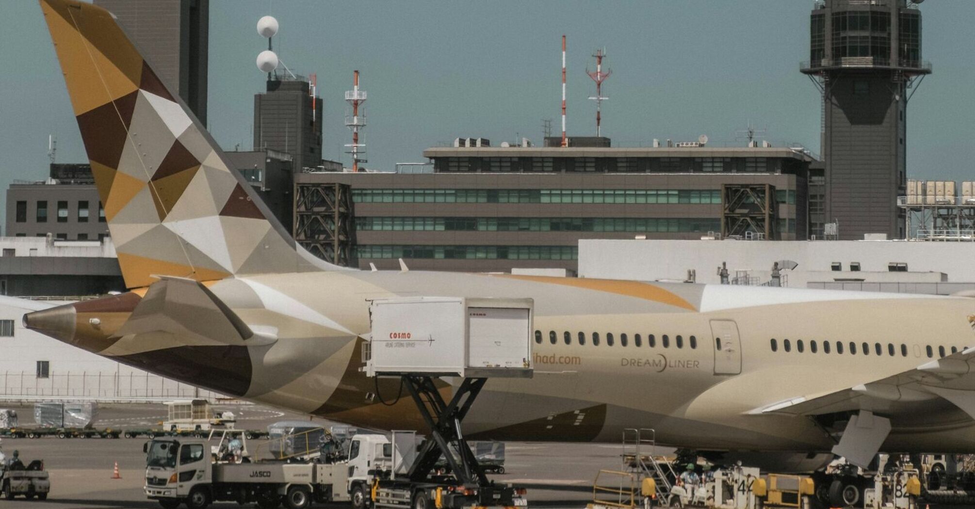 Etihad Airways plane at the airport with cargo loading and ground crew in operation