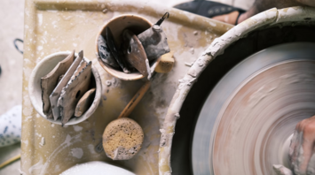Pottery tools and spinning wheel in use