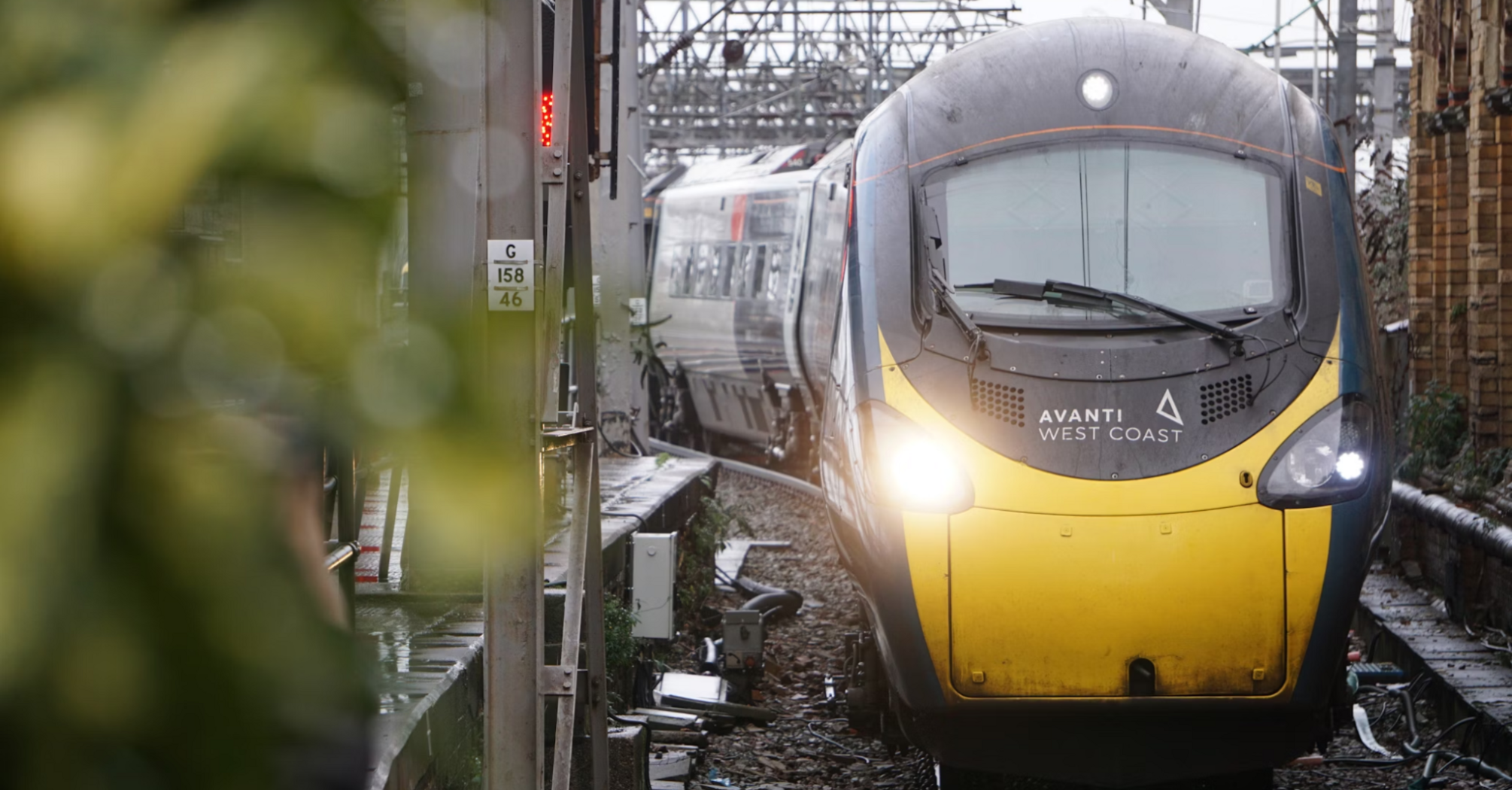 A stationary Avanti West Coast train at a railway station during overcast weather