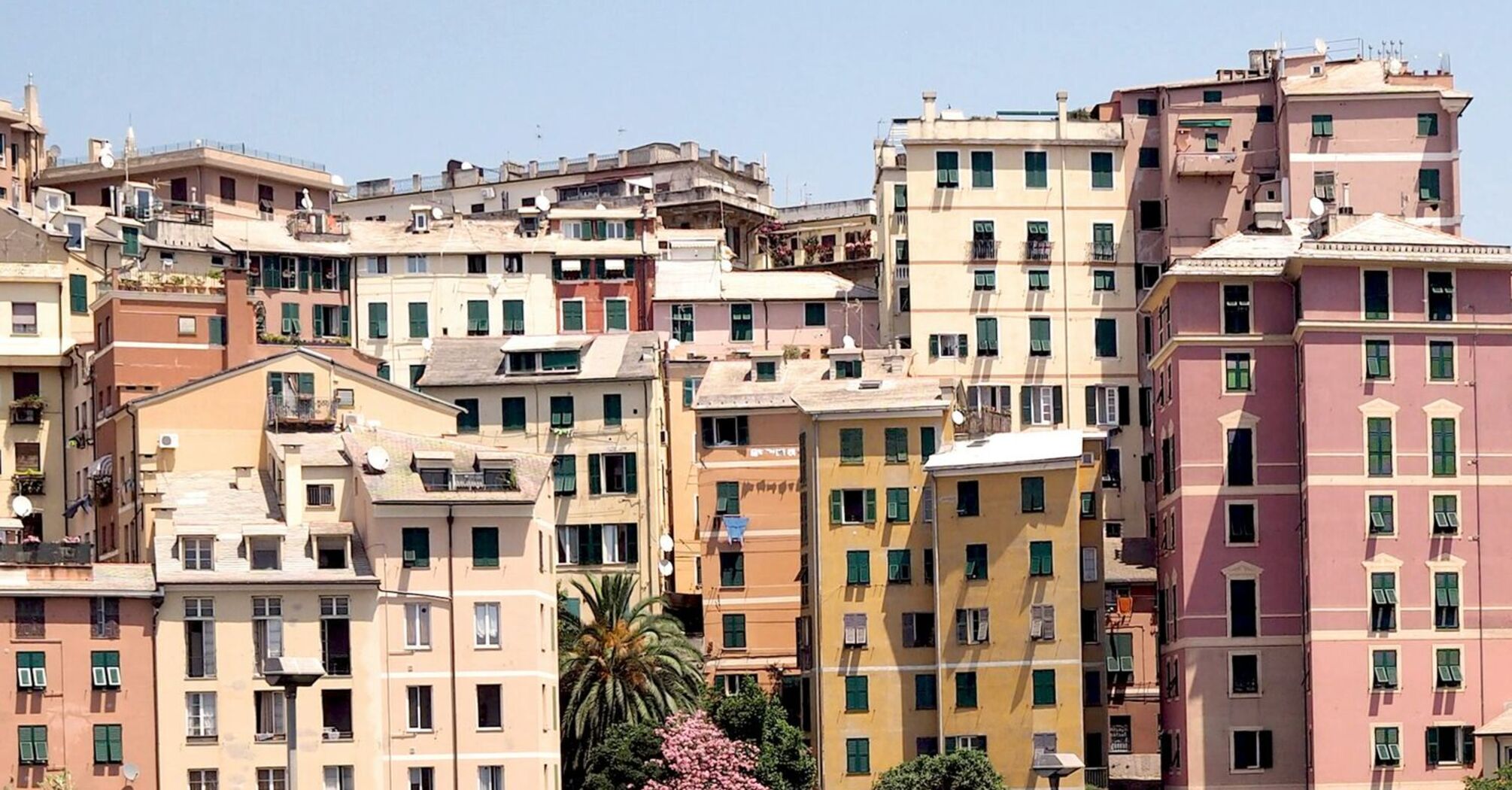 Colorful residential buildings in Genoa with green overpasses in the foreground