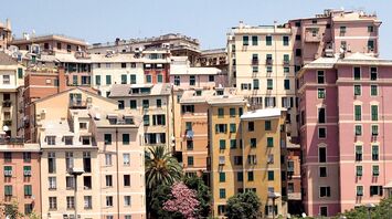 Colorful residential buildings in Genoa with green overpasses in the foreground