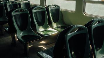 Empty green seats inside a public transport vehicle illuminated by sunlight through the windows