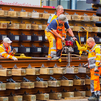 Workers in high-visibility clothing installing and maintaining railway tracks