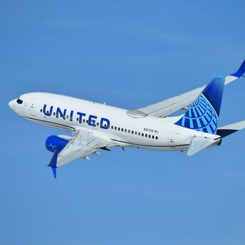 United Airlines aircraft taking off under clear blue sky