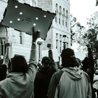 Protesters holding placards during a public demonstration in an urban area