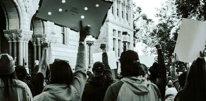 Protesters holding placards during a public demonstration in an urban area