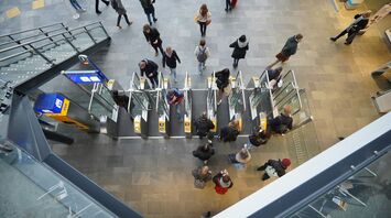 Travellers passing through automated gates at an airport terminal
