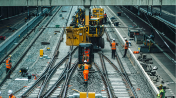 Railway engineers carrying out track maintenance and upgrades on a busy mainline