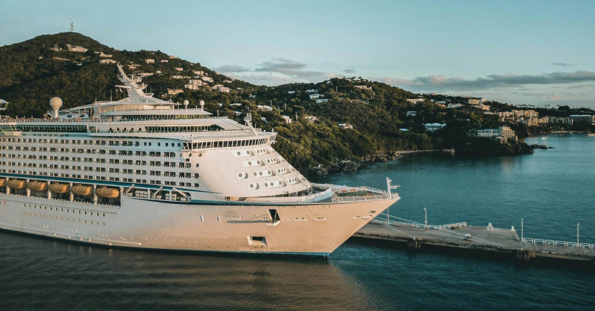 Cruise ship docked at a Caribbean island port during sunset