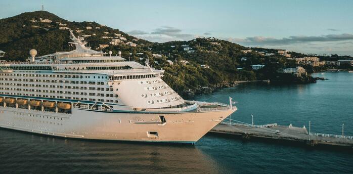 Cruise ship docked at a Caribbean island port during sunset