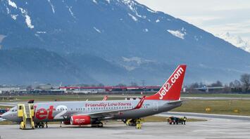Jet2 aircraft parked at an airport with snow-capped mountains in the background